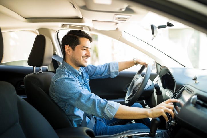 Man switching radio station while driving